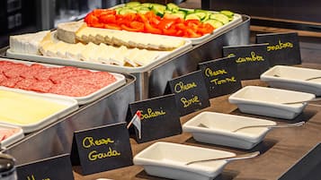 A buffet with various food options labeled, including ham, cheese, and tomato.