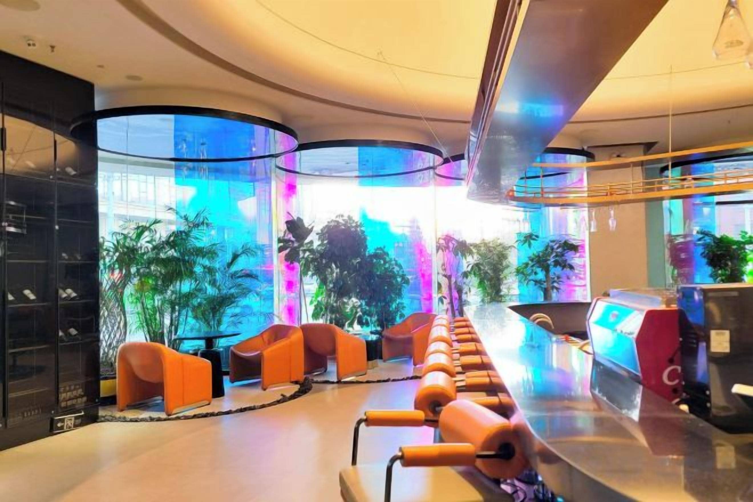 A modern lobby with seating, a reception desk, and large windows.