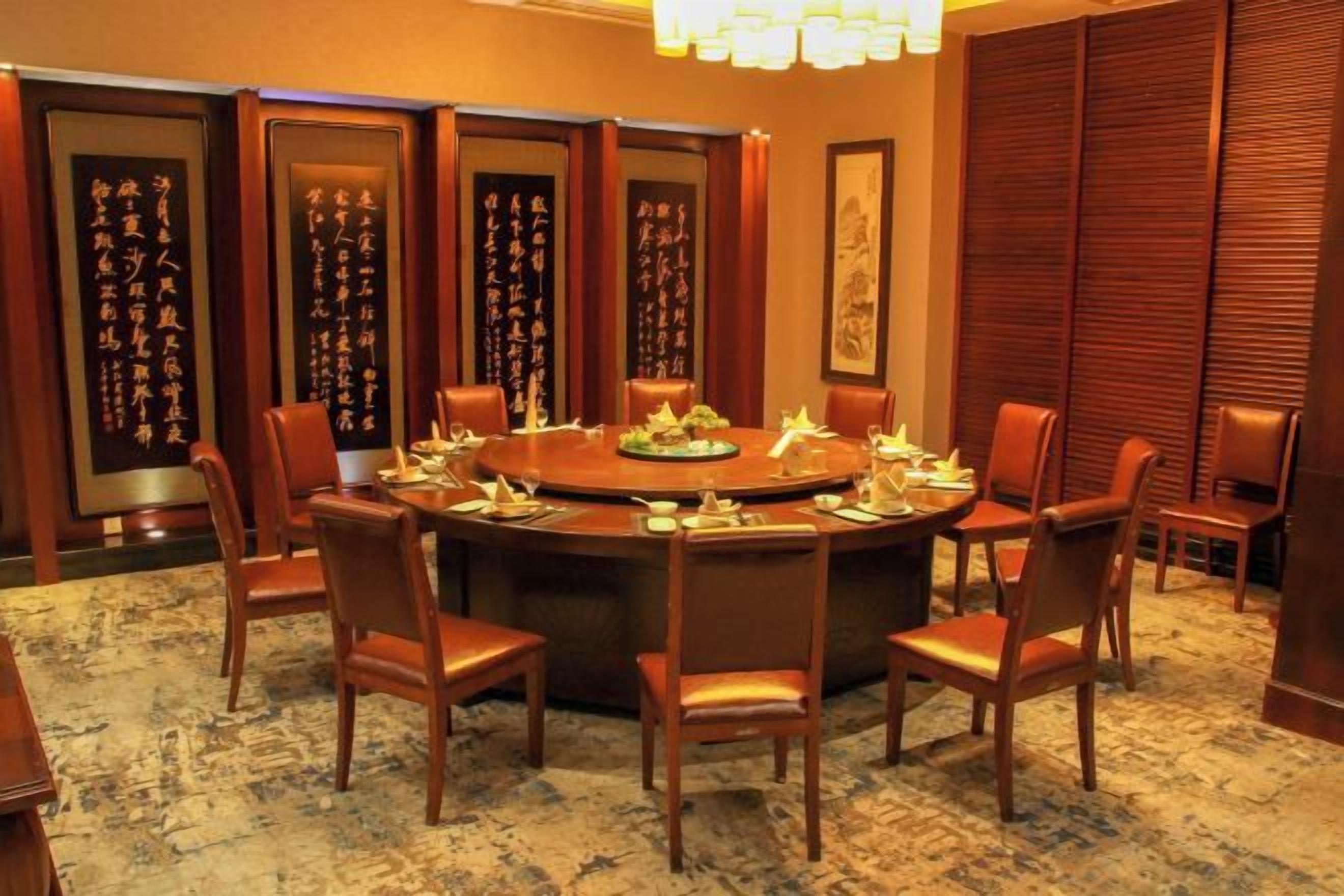 A conference room with a round table, chairs, and traditional decor.