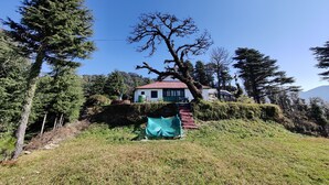 A house with a red roof, surrounded by trees and a grassy area. - Pre Independence 2 BHK Bungalow,dalhousie,himachal (Dalhousie)