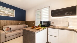 Une cuisine moderne dotée d’un four à micro-ondes encastré, d’un plan de travail en bois et d’une armoire blanche.