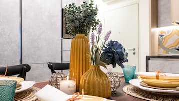 Een eettafel gedekt met borden, een kaars en decoratieve vazen.