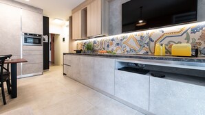 A modern kitchen with a built-in oven, a dishwasher, and a colorful backsplash. - Renzi 23 - Two Bedroom Apartment, Sleeps 6 (Cattolica)