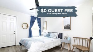 A bedroom with a bed, a desk, a chair, a ceiling fan, and a door. - 2BR Ensuite | Near UT & The Domain (Austin)