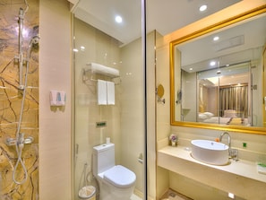 A modern bathroom with a glass-enclosed shower, a toilet, and a sink with a large mirror. - Vienna International Hotel (Ye County)