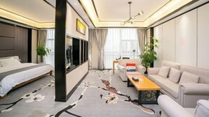 A modern hotel room with a bed, sofa, coffee table, and a large window. - Yuting Impression Hotel (Zhongjiang)