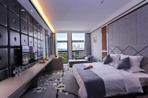 A modern hotel room with a large bed, a seating area with a view, and a wall of storage cubes. - Yuting Impression Hotel (Zhongjiang)