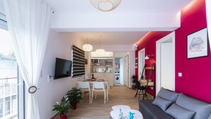 A modern apartment with a dining area, kitchen, and living room.