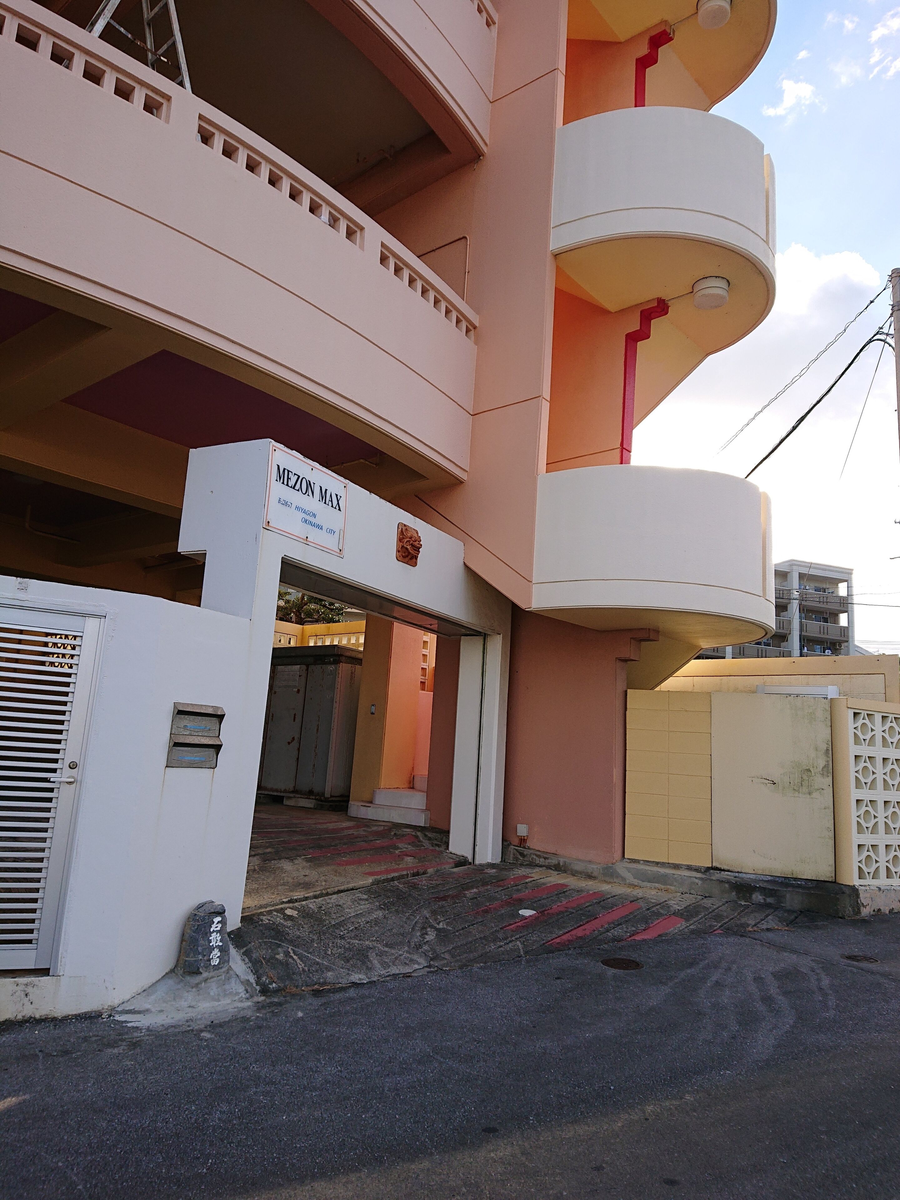 A building with a sign reading "MEZON MAX" and a gated entrance.