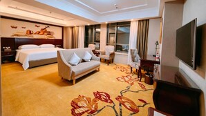 A hotel room with a bed, sofa, TV, and a large window. - Vienna Hotel (Longmen)
