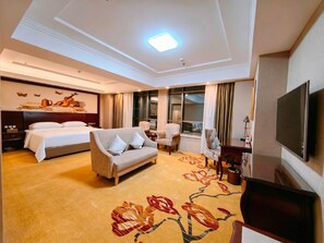 A hotel room with a bed, sofa, TV, and a large window. - Vienna Hotel (Longmen)