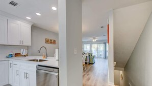 A modern kitchen with white cabinets, a dishwasher, and a sink. - PRIVATE BEACH - Gulf Peeks - Newly renovated - Bikes included - 7 Palms (Panama City Beach)