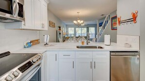 A modern kitchen with white cabinets, stainless steel appliances, a built-in oven, and a dishwasher. - PRIVATE BEACH - Gulf Peeks - Newly renovated - Bikes included - 7 Palms (Panama City Beach)