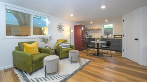 A compact living space with a green sofa, a dining area, and a kitchen. - Bright and Modern Basement Apartment ✿ DT Neighborhood (Vancouver)