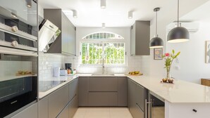 Eine moderne Küche mit großem Fenster, Edelstahlgeräten und einem klaren, minimalistischen Design.