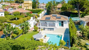 Ein Wohnhaus mit Swimmingpool, Solaranlage und gepflegtem Garten.