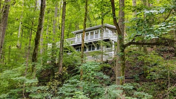 A treehouse with multiple levels, surrounded by dense forest.