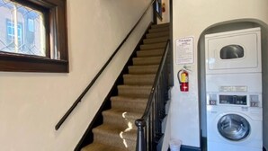 Eine Treppe mit Geländer, Teppichstufen und einem an der Wand befestigten Feuerlöscher.