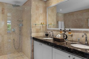 Une salle de bain moderne avec deux lavabos, un grand miroir et un espace douche.