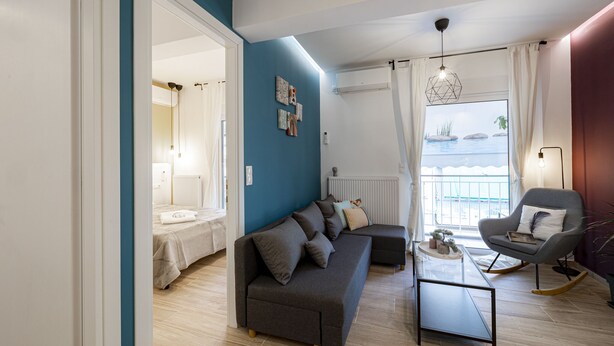 A modern living room with a sofa, a rocking chair, and a coffee table. - Calliope (Athenian apartment close to the center) (Athens)