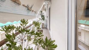 A balcony with a view of a building, a potted plant, and a tiled floor. - Calliope (Athenian apartment close to the center) (Athens)