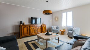 Un soggiorno moderno con un mobile in legno, una televisione, un divano e un tavolino.