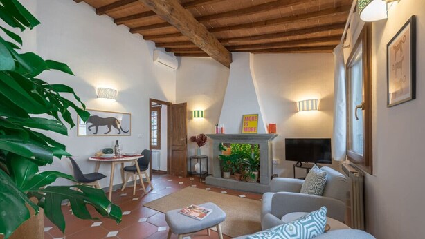 A cozy living room with a fireplace, a dining area, and a TV.