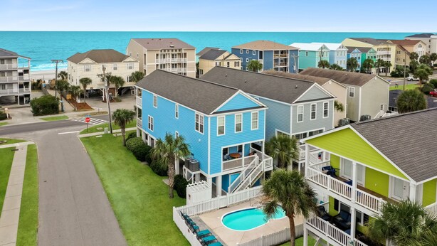 A coastal residential area with houses featuring balconies and a swimming pool. - Spacious 6-Bed Home w/ Private Pool & Beach Access (Surfside Beach)
