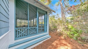 A covered porch with a view of the surrounding forest.