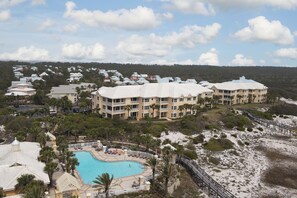 Ein Resort mit Schwimmbad, mehreren Gebäuden und Strand.