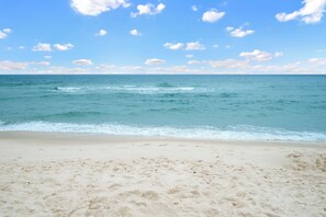 Ein Strand mit blauem Himmel und ruhiger See.