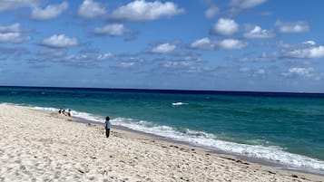 På stranden, gratis strandtransport, parasoller, badehåndklæder
