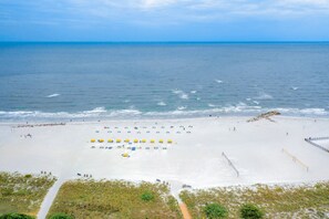 A beach with umbrellas and people.