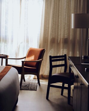 A hotel room with a bed, a desk, a chair, and a lamp. - SALT of Akagera (Mwiri)