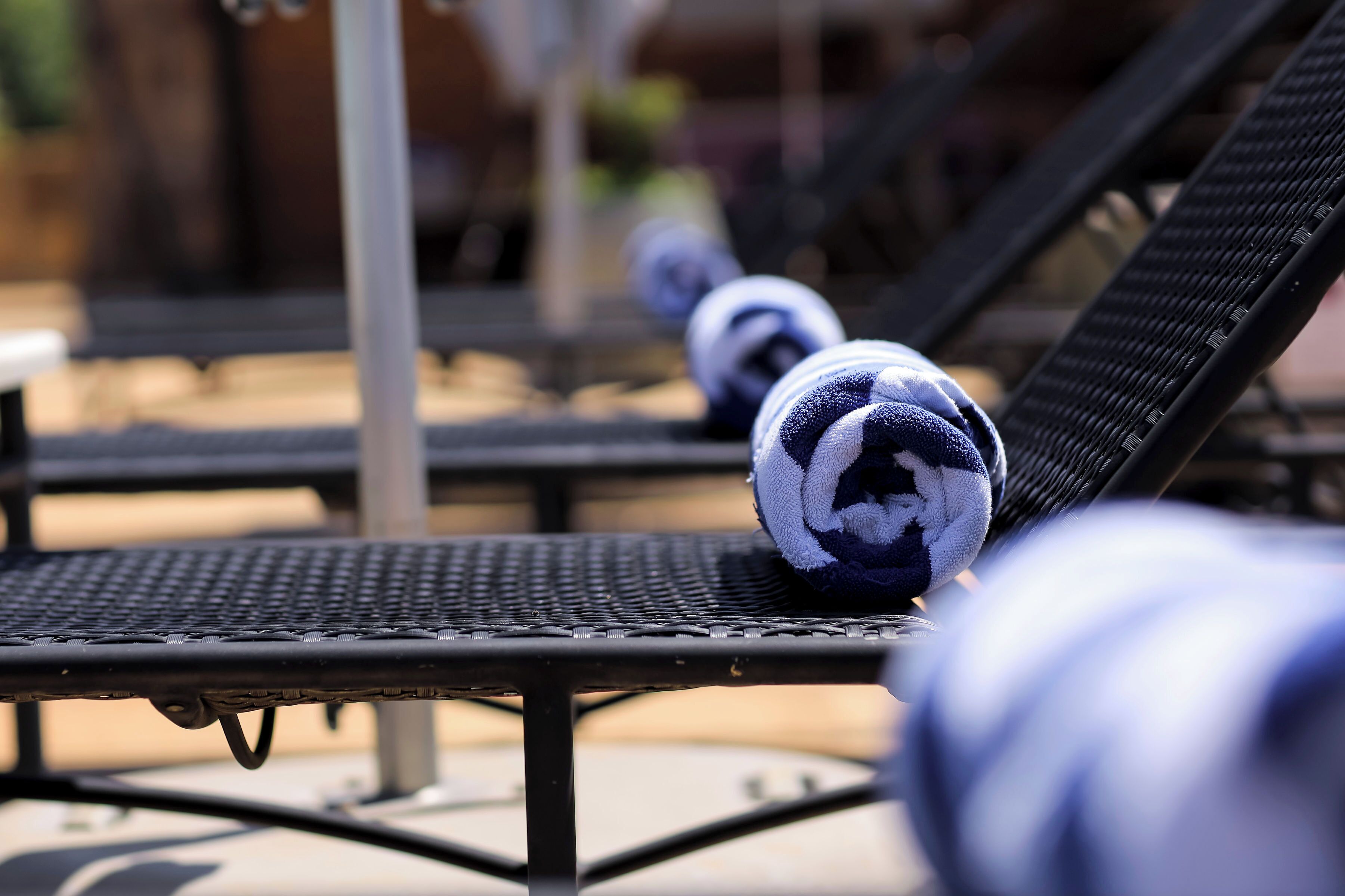 A row of lounge chairs with towels.