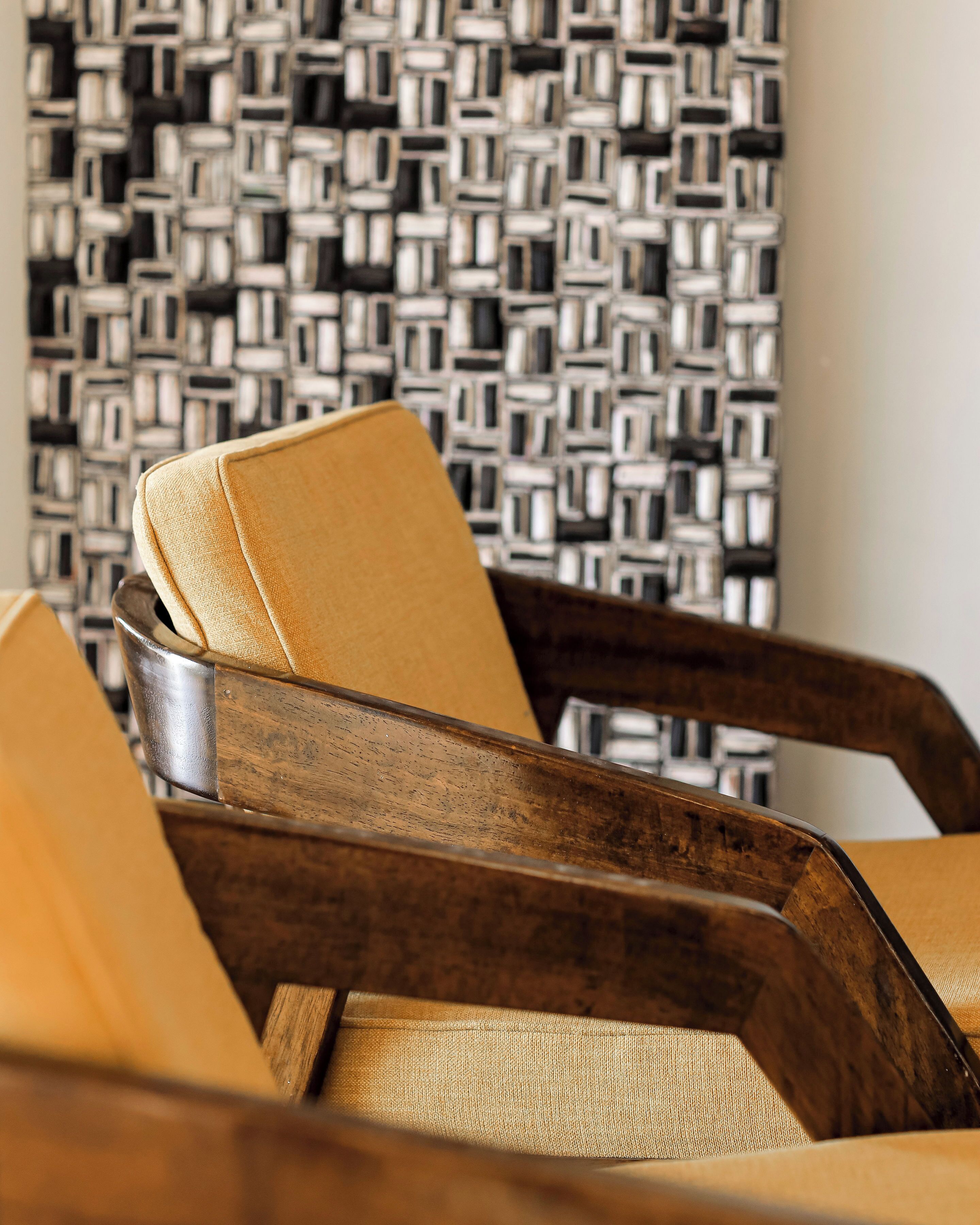 A close-up of a wooden chair with a textured fabric cushion.