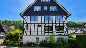Ein traditionelles Fachwerkhäuschen mit vielen Fenstern und einem Satteldach.