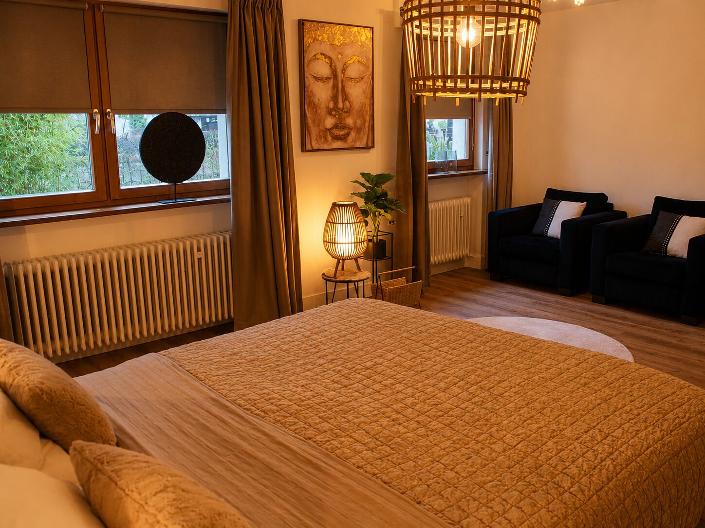 Ein Schlafzimmer mit einem großen Bett, einem Schlafsofa, einer Lampe und einem Fenster mit Vorhängen.