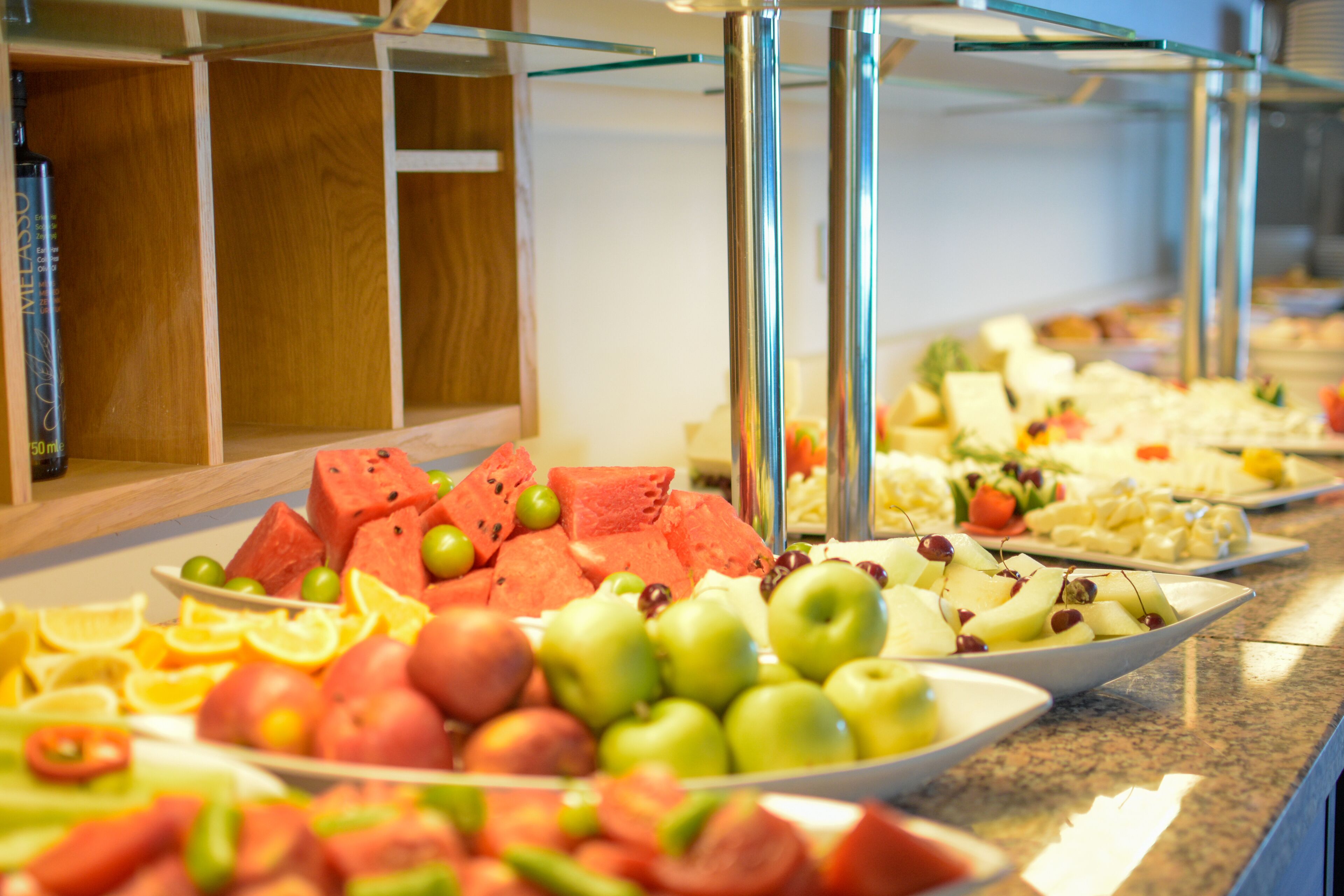A buffet with various fruits and cheeses.