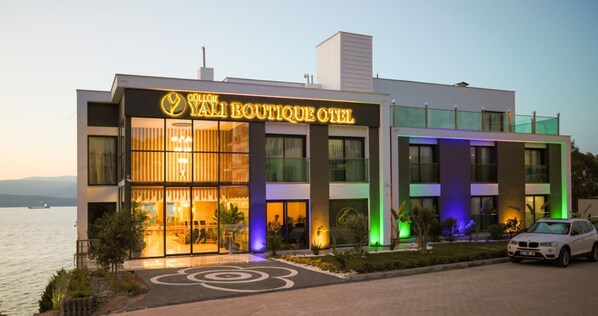 Un hôtel moderne, doté d’une entrée bien visible, de grandes fenêtres et d’une voiture garée devant.