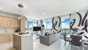 A modern living space with a kitchen, dining area, and a sofa.