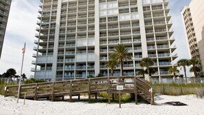 Un hotel de varios pisos con un diseño arquitectónico moderno, que cuenta con balcones y acceso directo a la playa.