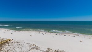 Una playa con cielo despejado y mar tranquilo.