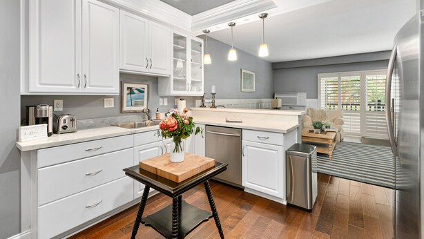 A modern kitchen with white cabinets, a wooden table, and a stainless steel refrigerator. - Condo on property at LaCosta Golf Resort & Spa 689 (Carlsbad)