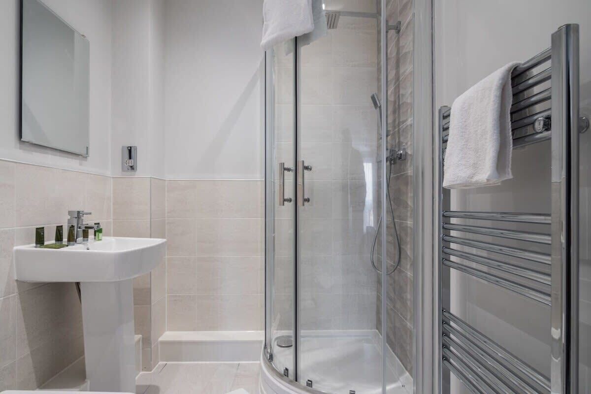 Bathtub, hair dryer, towels, shampoo