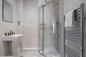 Bathtub, hair dryer, towels, shampoo