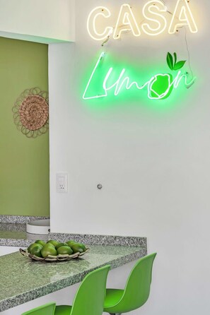 Une cuisine ornée d’un néon affichant le mot « CASA Limon » et d’une décoration murale tissée.