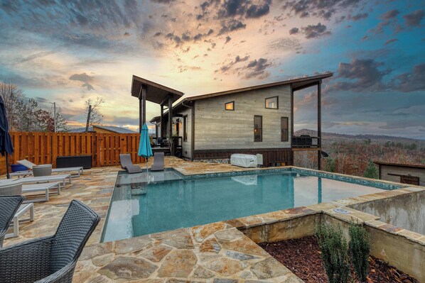 A modern house with a swimming pool, outdoor furniture, and a wooden deck. - Water's Edge 2 - Private pool & mountain views (Mineral Bluff)