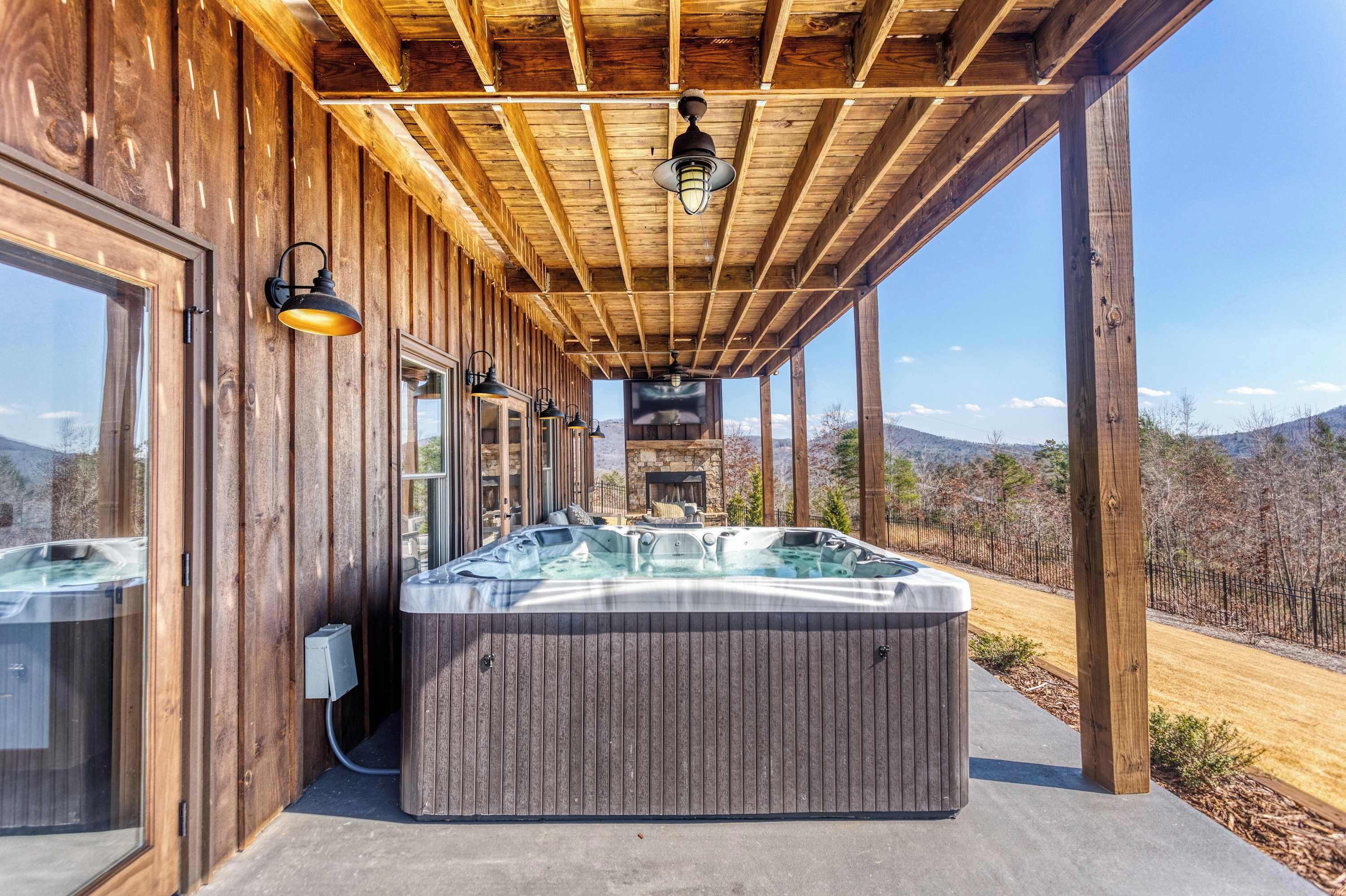 Un espace de détente en bois comprenant des bains à remous, une pergola et une vue sur les montagnes.