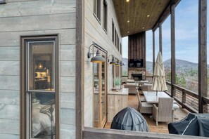 A wooden deck with outdoor furniture, a TV, and a view of the mountains. - Water's Edge 2 - Private pool & mountain views (Mineral Bluff)